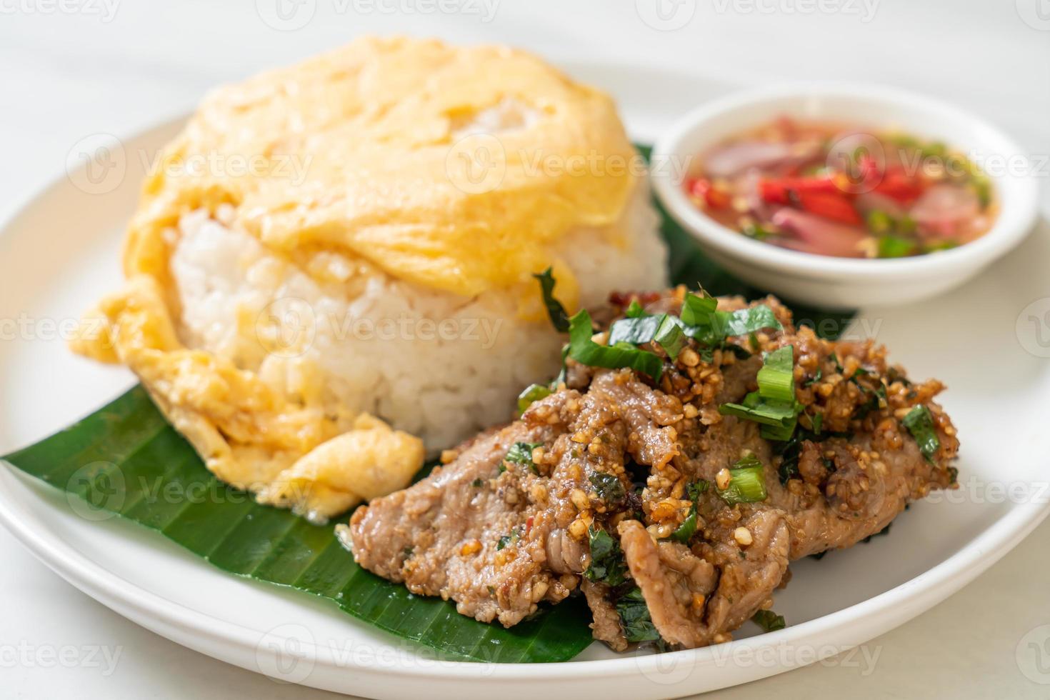 ei op gegarneerde rijst met gegrild varkensvlees en pikante saus - Aziatisch eten foto