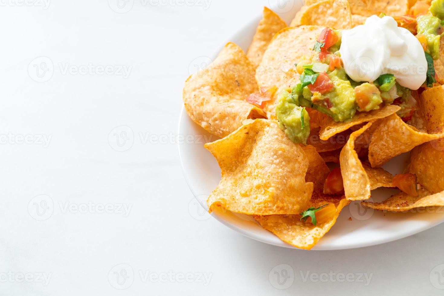 Mexicaanse nachos tortillachips met jalapeno, guacamole, tomatensalsa en dip foto