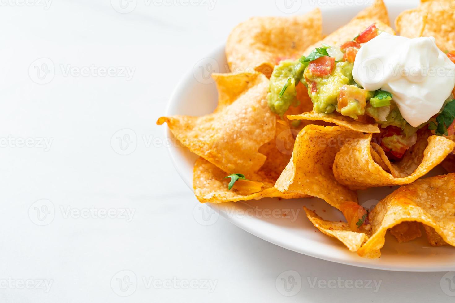 Mexicaanse nachos tortillachips met jalapeno, guacamole, tomatensalsa en dip foto