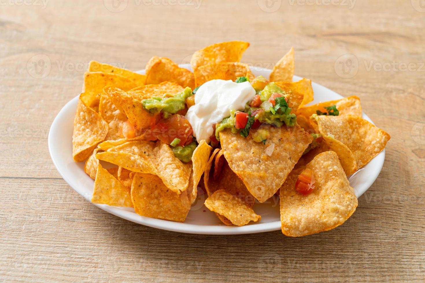 Mexicaanse nachos tortillachips met jalapeno, guacamole, tomatensalsa en dip foto