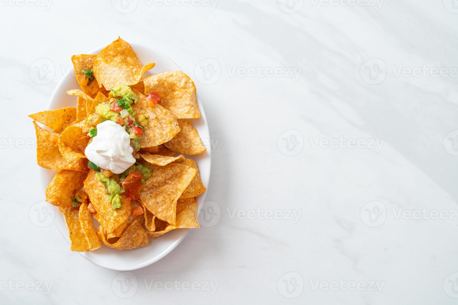 Mexicaanse nachos tortillachips met jalapeno, guacamole, tomatensalsa en dip foto