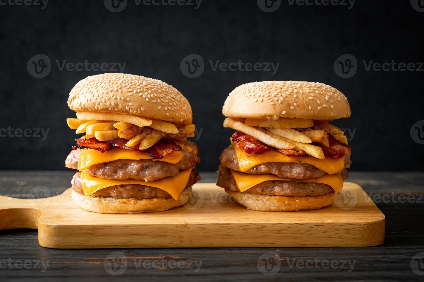 varkenshamburger of varkensburger met kaas, spek en frietjes foto