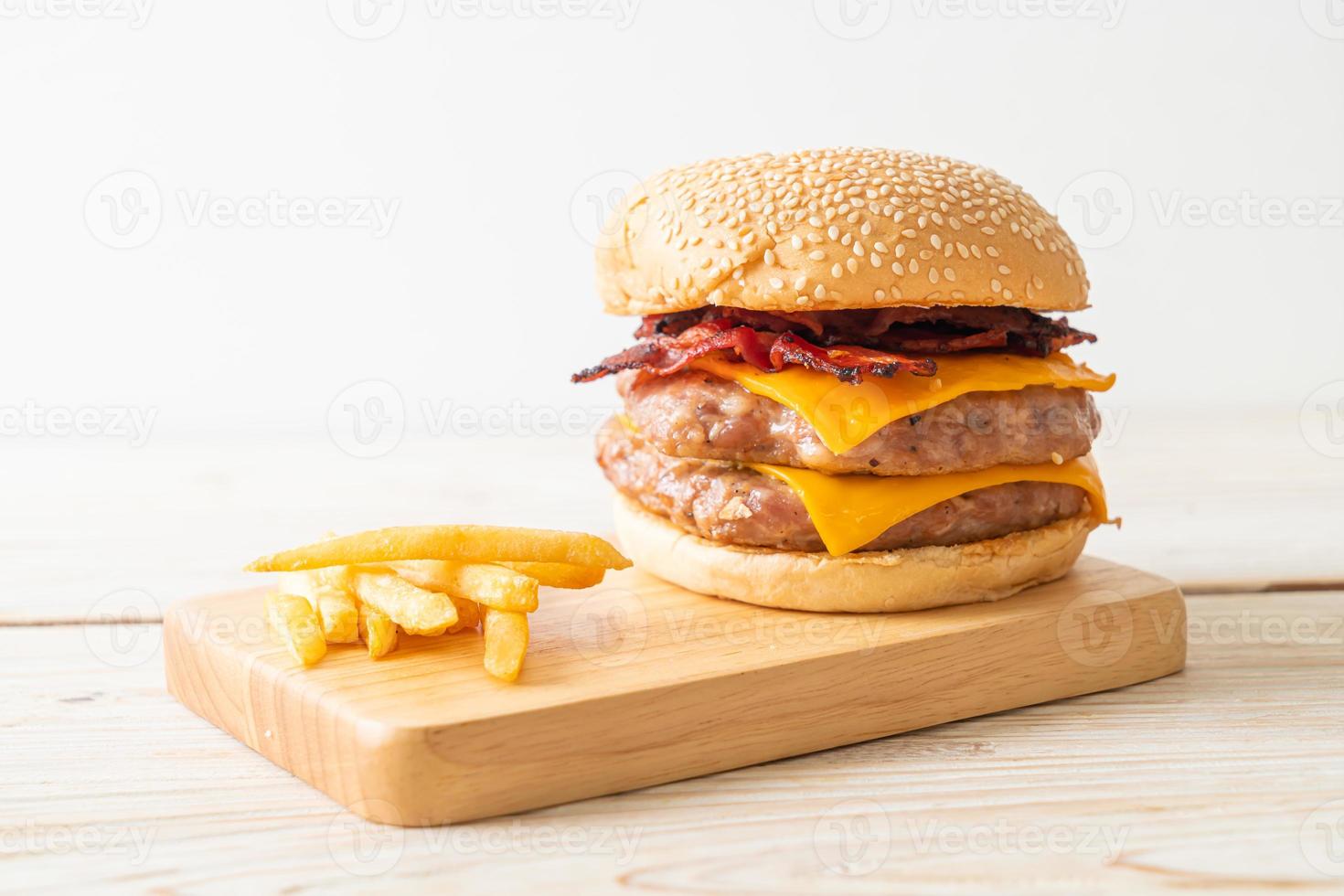 varkenshamburger of varkensburger met kaas, spek en frietjes foto