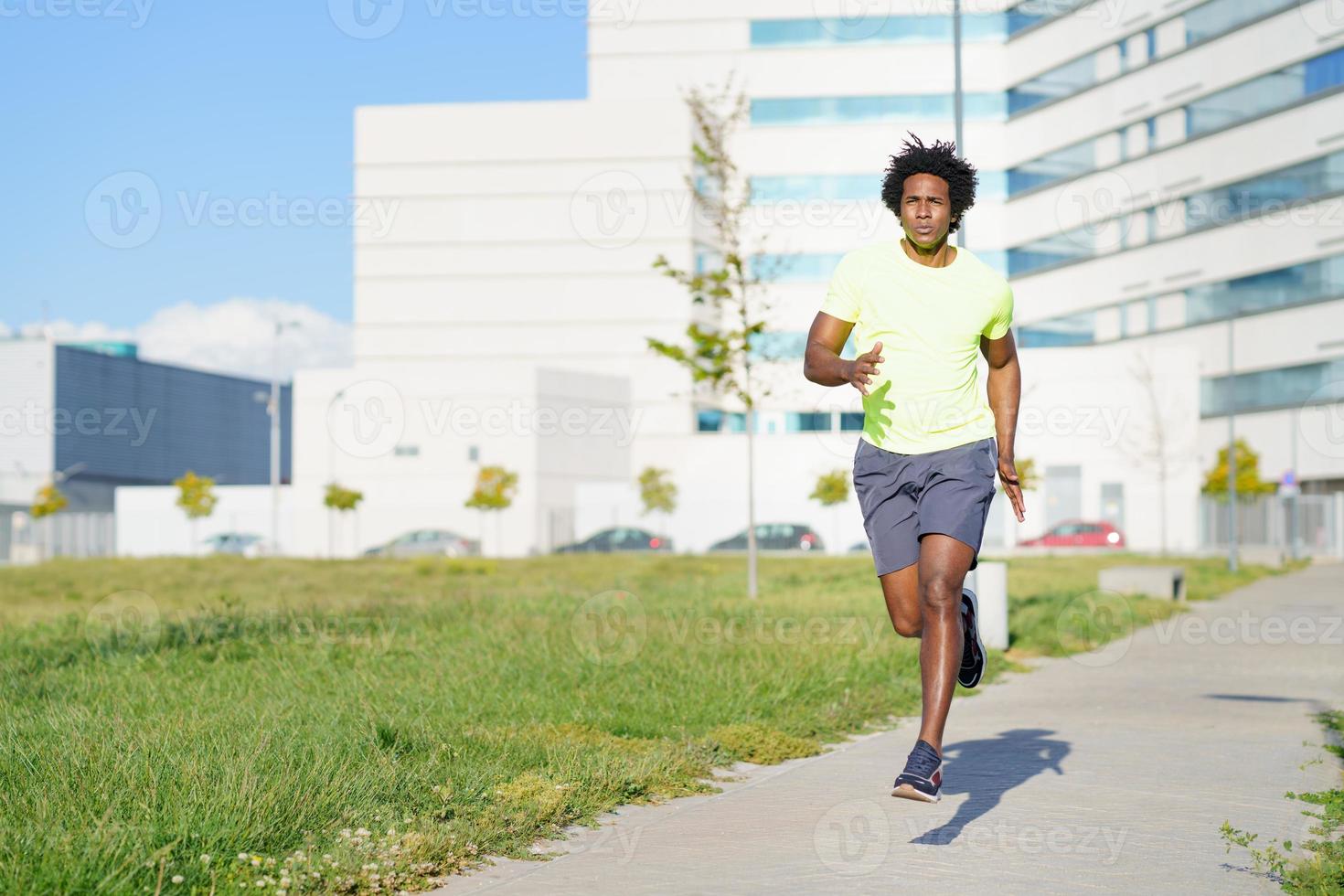 zwarte atletische man loopt in een stadspark. foto