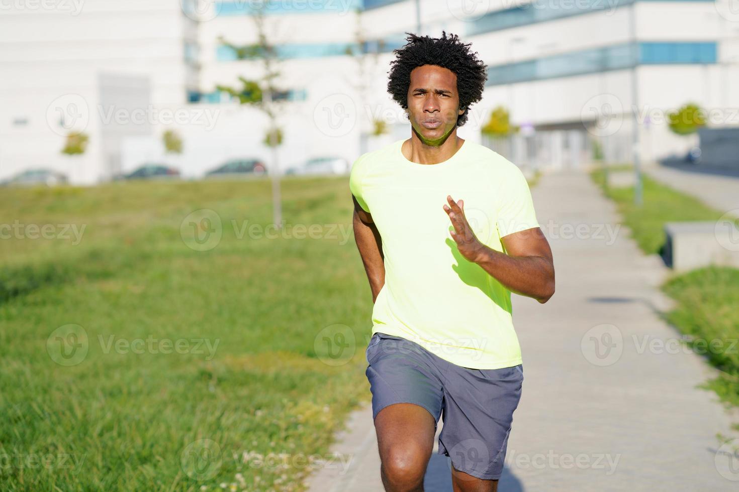 zwarte atletische man loopt in een stadspark. foto