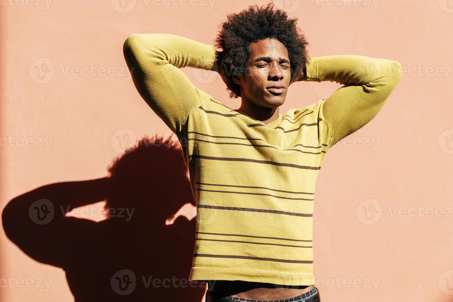 Cubaanse zwarte man geniet van de Andalusische zon met zijn ogen dicht foto