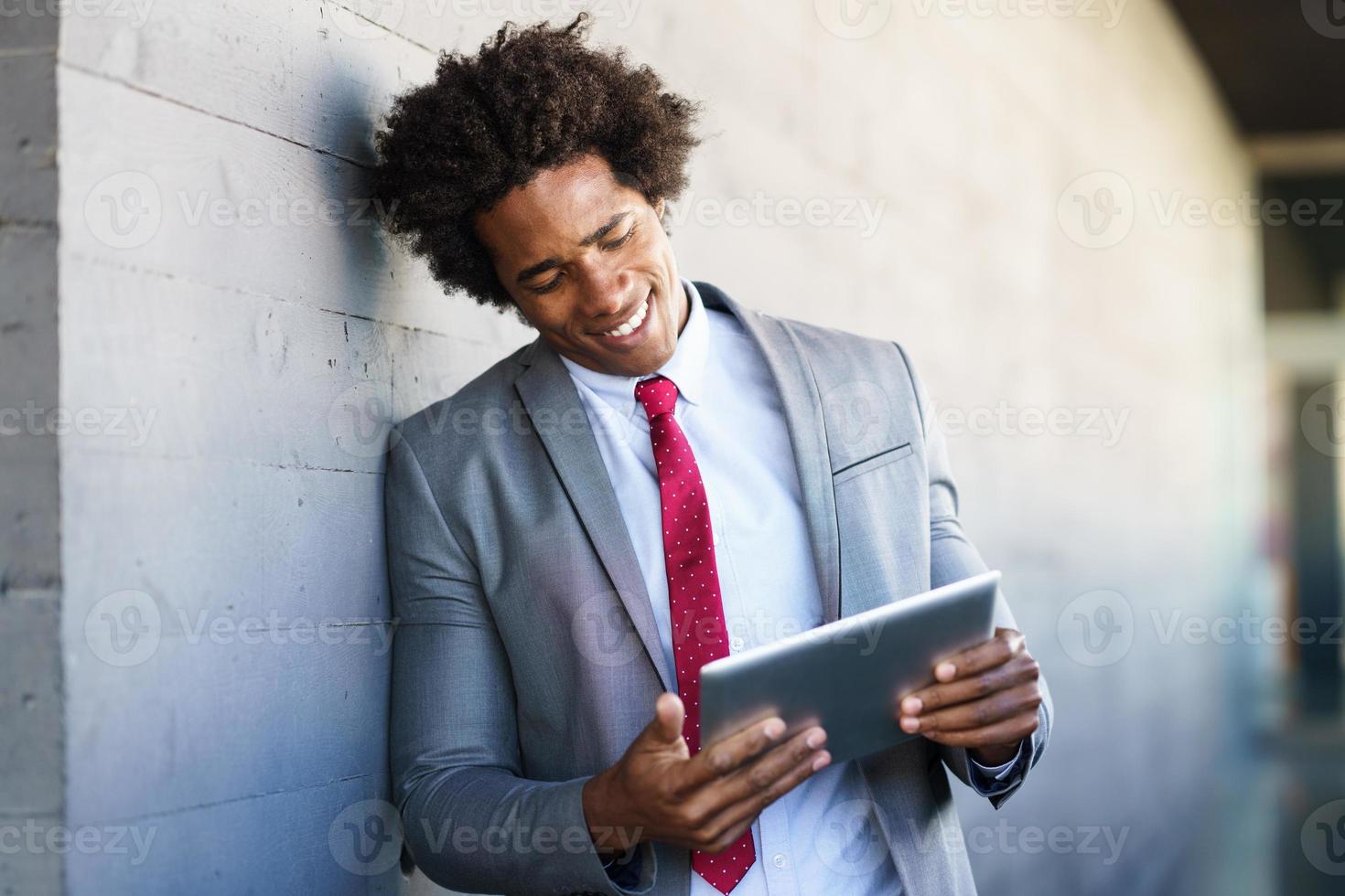 zwarte zakenman met behulp van een digitale tablet in stedelijke achtergrond foto