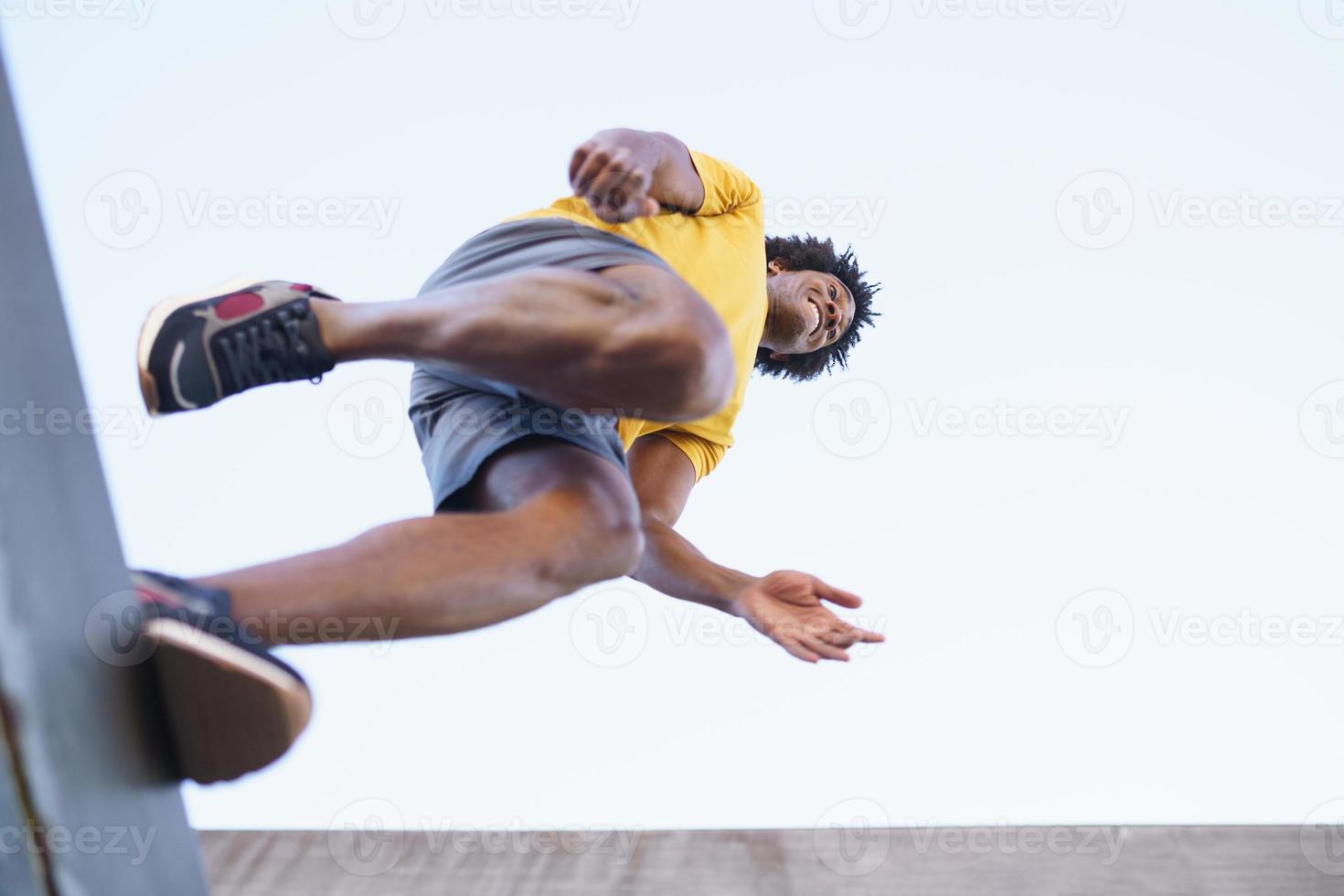 weergave van onderen van zwarte man springen op zijn vlucht. foto