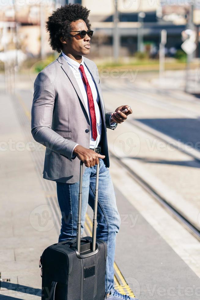 zwarte zakenman die op de volgende trein wacht foto