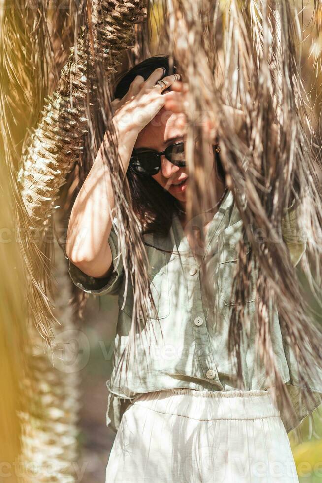 jong vrouw door palm bomen foto