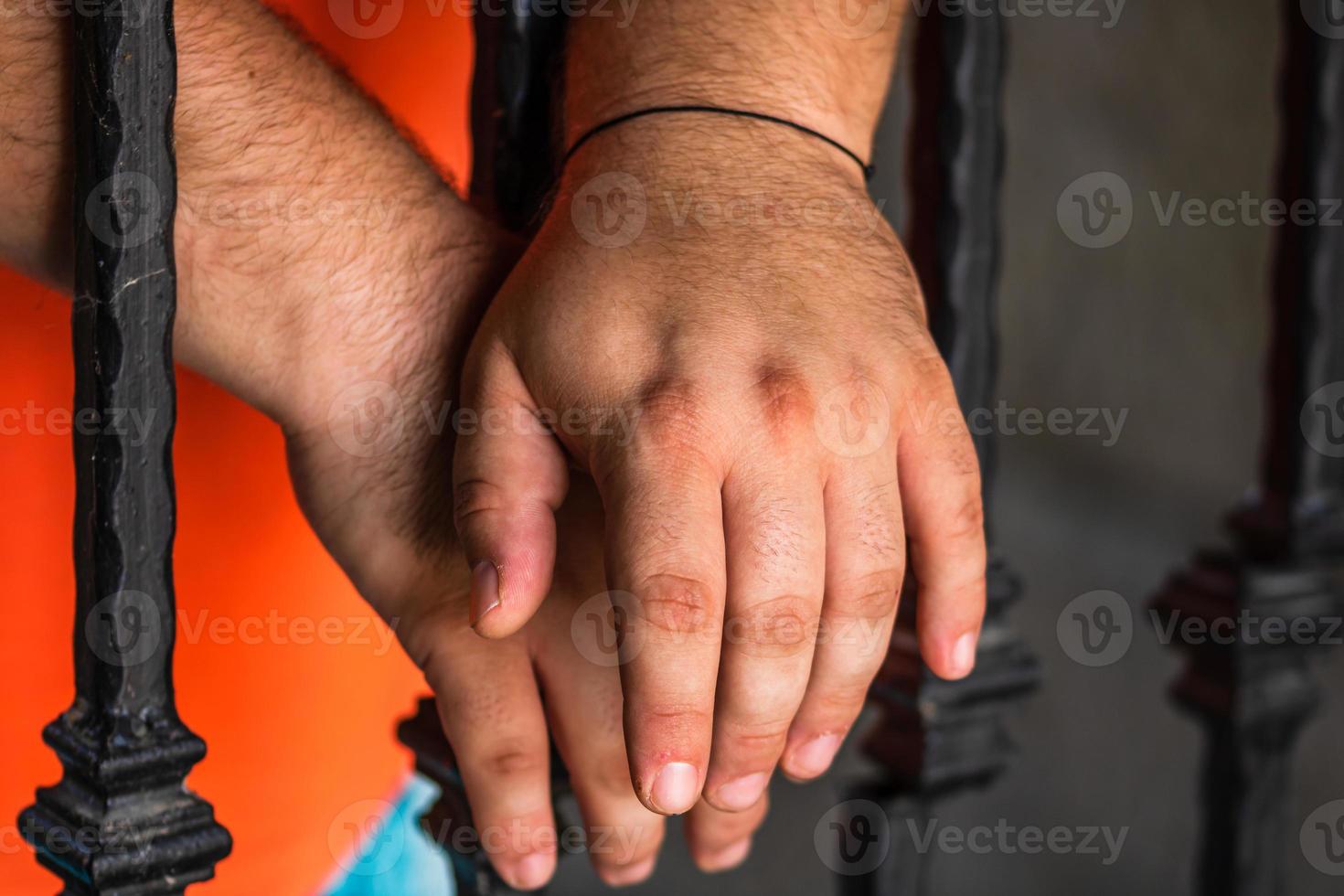 gevangene man hand in hand op gevangenis bars. handen op de tralies van de gevangenis. foto