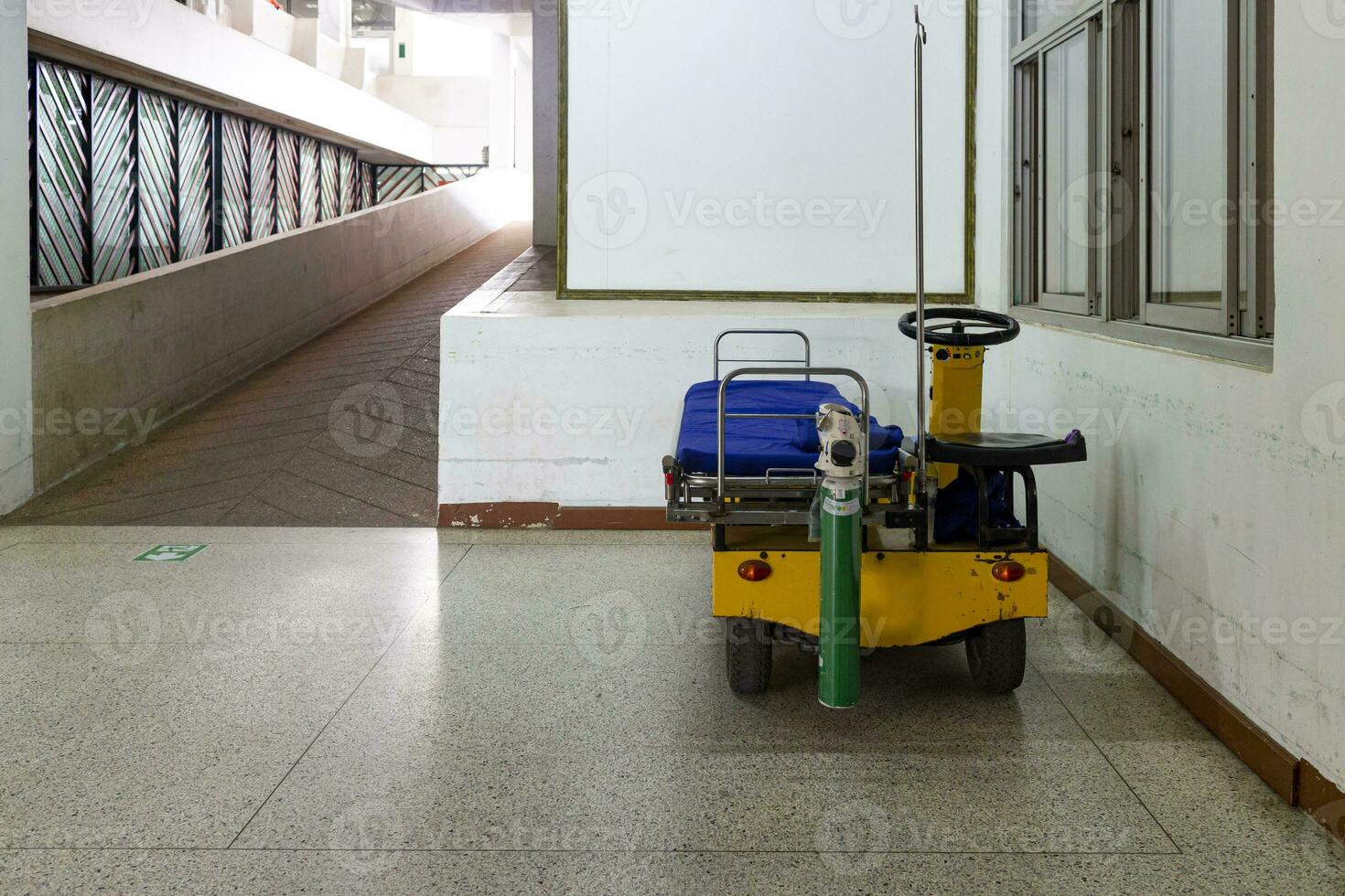 rolstoel ev, uitgerust met bed en zuurstof tank voor vervoeren patiënten binnen de ziekenhuis gebouw foto