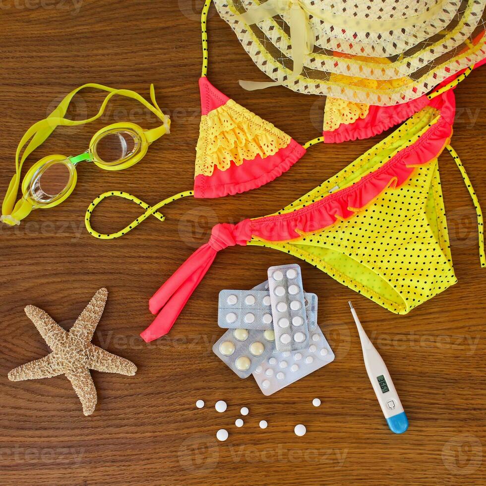 zomer strand accessoires en geneeskunde Aan de tafel. de concept van geneesmiddel verplicht in de reis foto