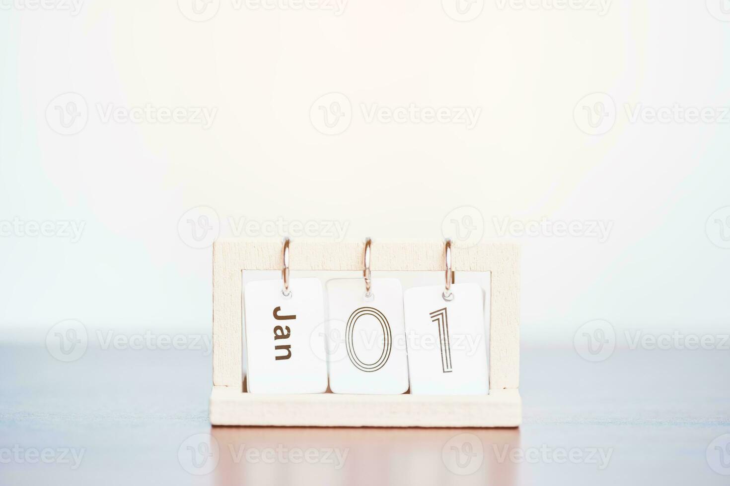 een kalender presentatie van de datum van januari 1e is Aan een houten tafel met een zacht en teder oranje zonlicht van de buiten voor de concept van nieuw jaar festival. foto