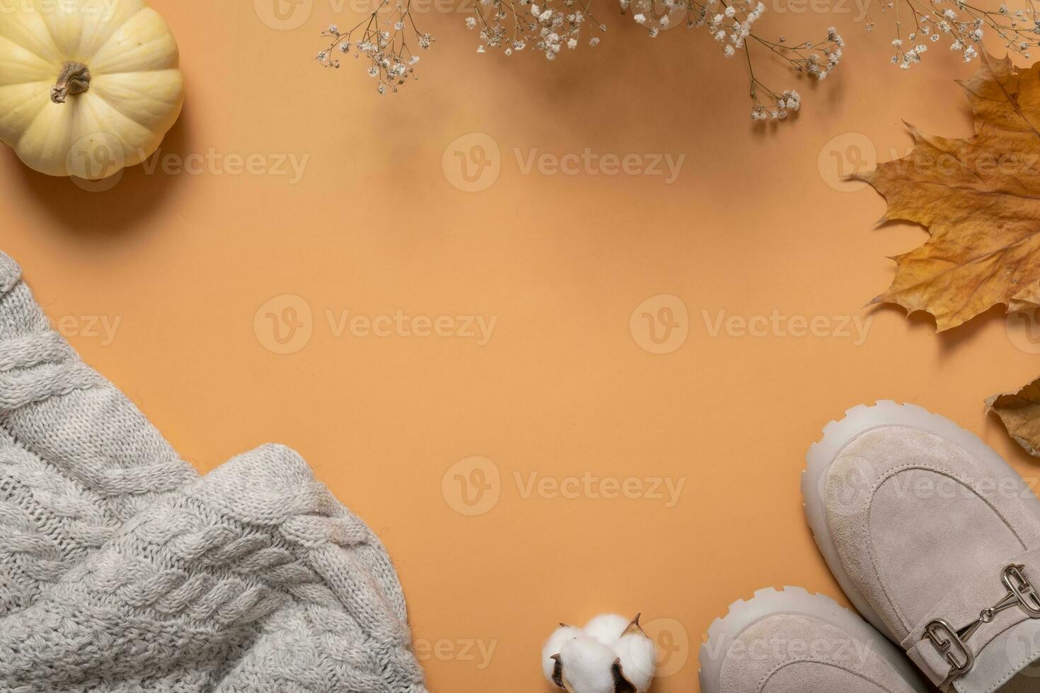 vrouw schoenen, trui met herfst bladeren en pompoen Aan oranje achtergrond met kopiëren ruimte top visie, vlak leggen. foto