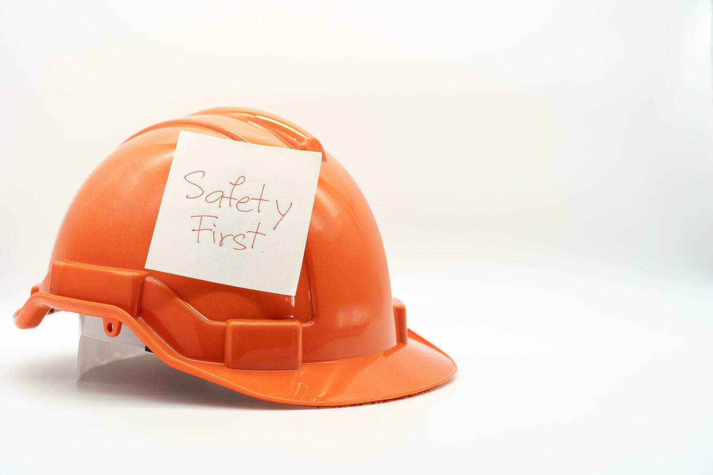 oranje veiligheid hoed met bericht veiligheid eerst. moeilijk hoed geïsoleerd Aan wit achtergrond. foto