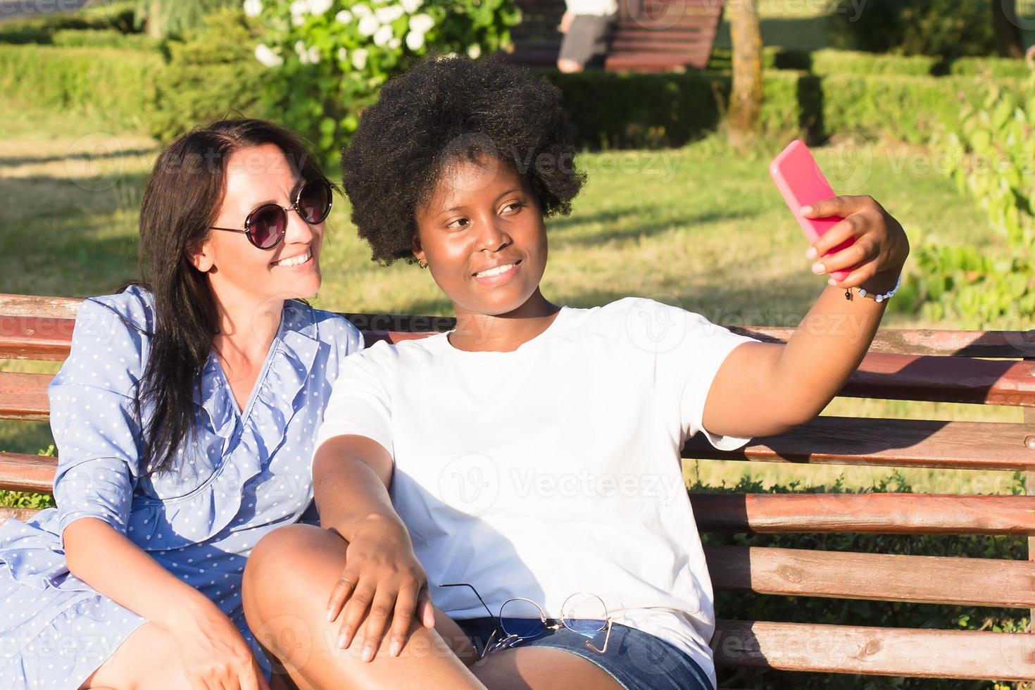 gelukkige meisjes van verschillende nationaliteiten maken selfies in de zomer foto