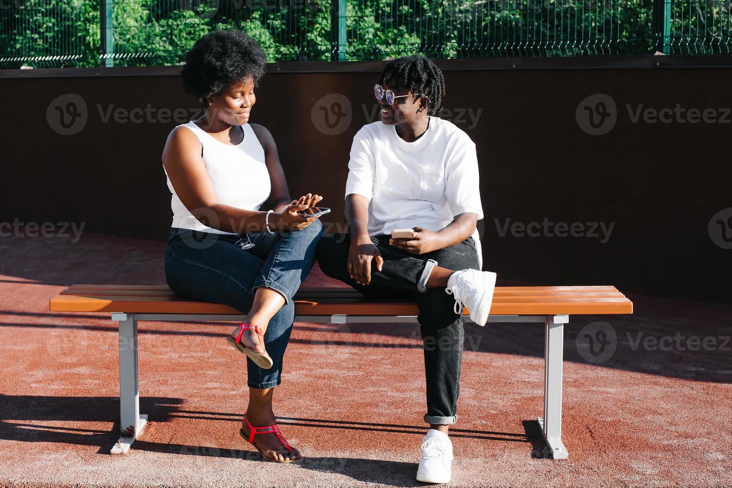 twee gelukkige Afro-Amerikaanse vrouwen communiceren en lachen op straat foto