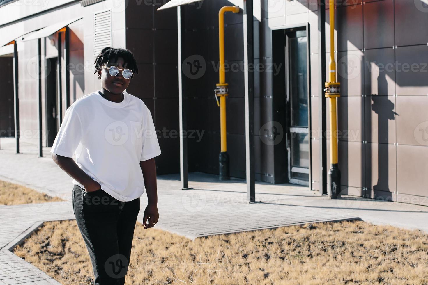 gelukkige Afro-Amerikaanse vrouw loopt in de zomer over straat foto