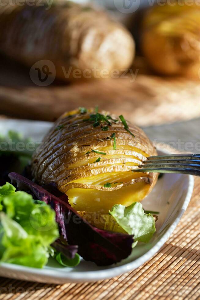 gebakken jasje aardappelen met duik, gemengd groen salade bladeren en hennep olie foto