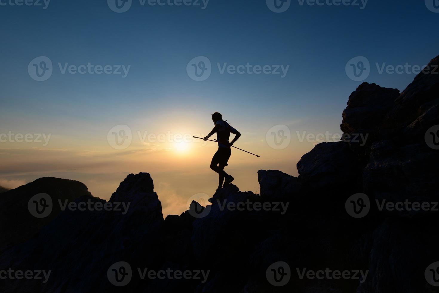 sky runner in silhouet bij zonsondergang tussen de rotsen foto