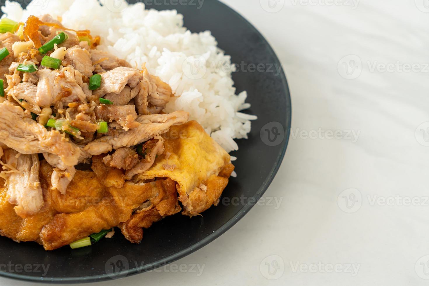 roergebakken varkensvlees met knoflook en ei gegarneerd op rijst - Aziatische stijl food foto