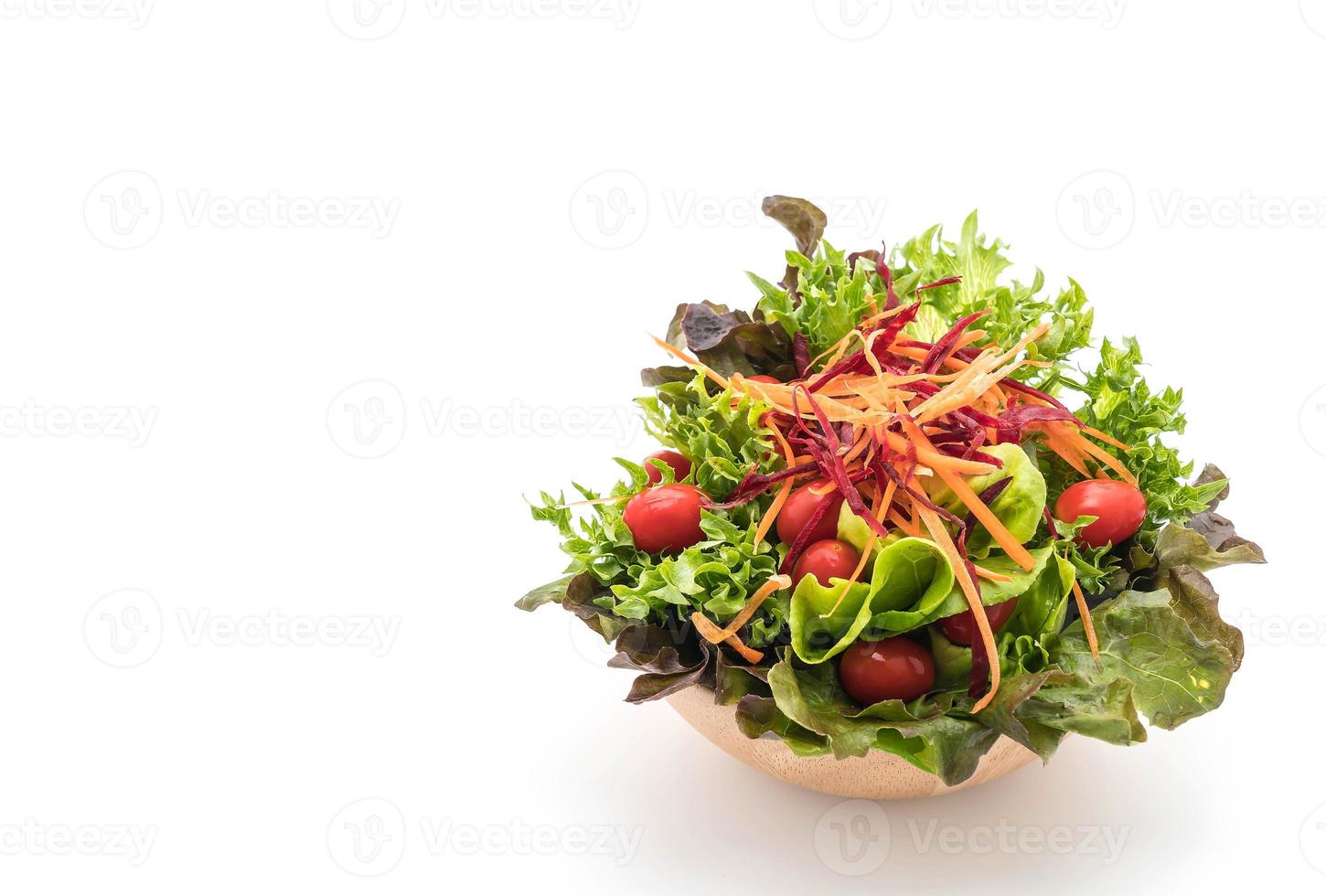 gemengde salade in houten kom op witte achtergrond foto