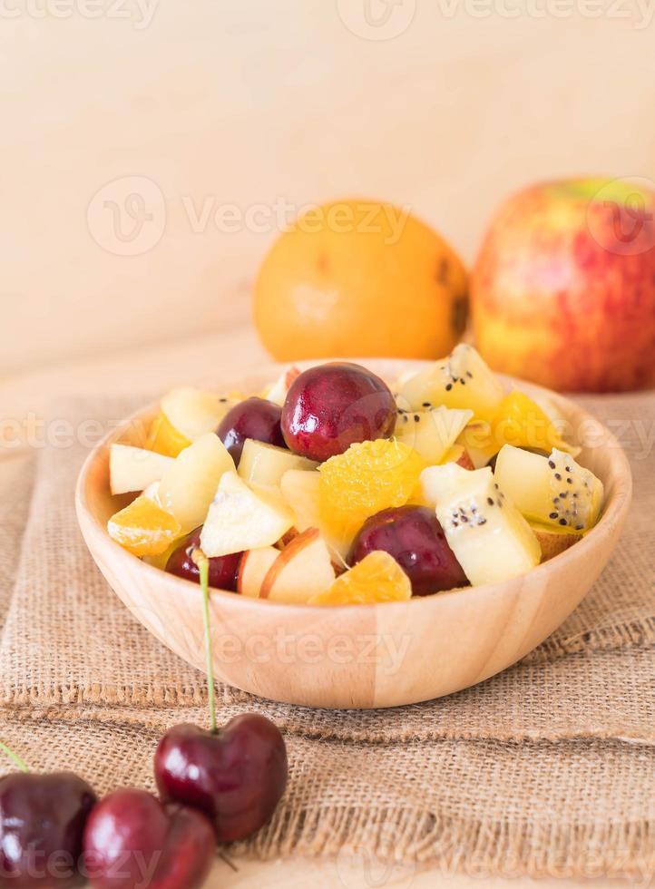 gemengd gesneden fruit in houten kom foto