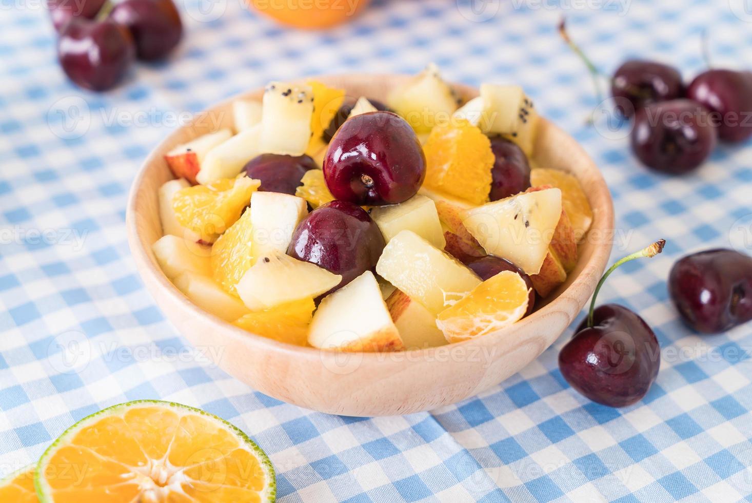 gemengd gesneden fruit in houten kom foto