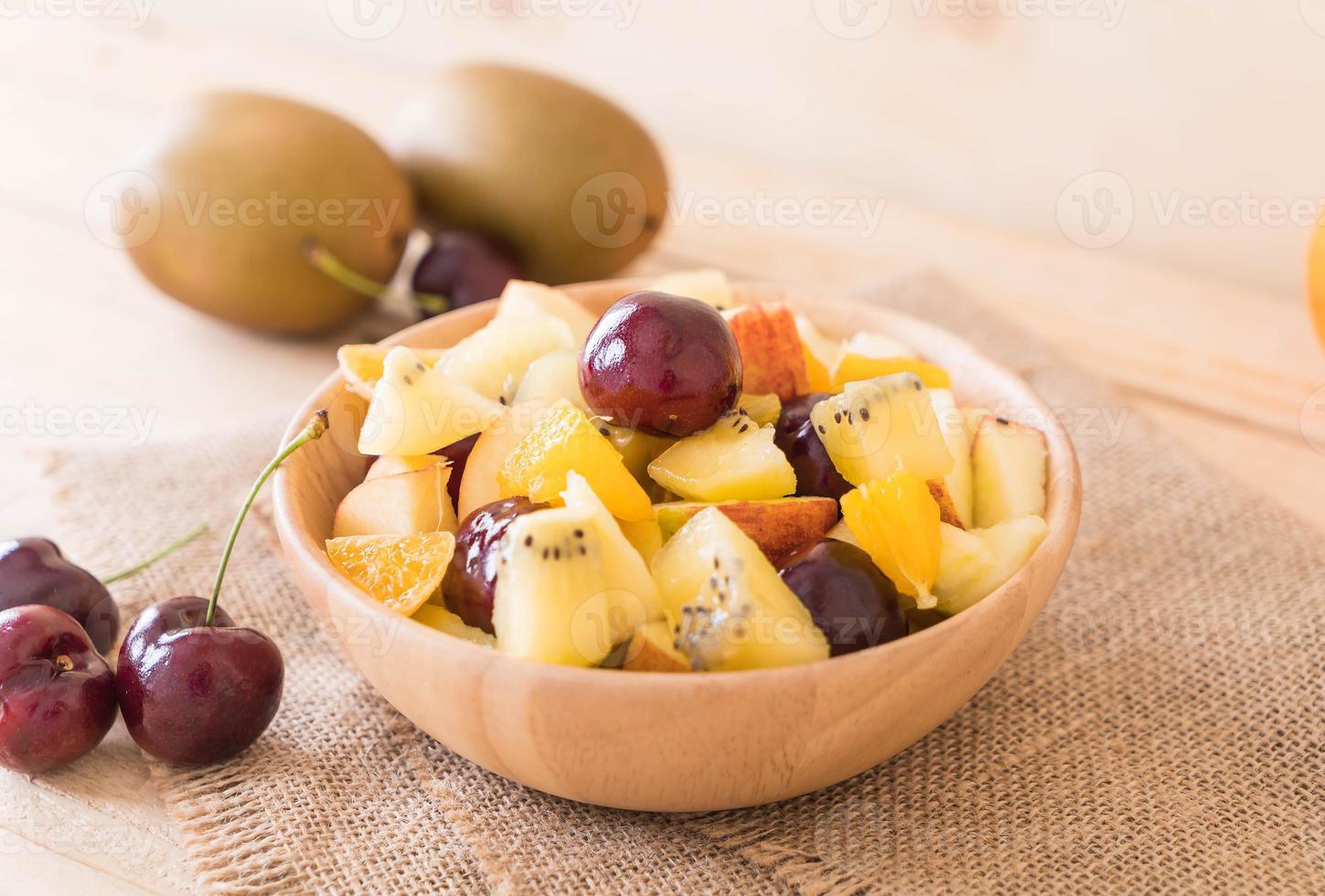 gemengd gesneden fruit in houten kom foto