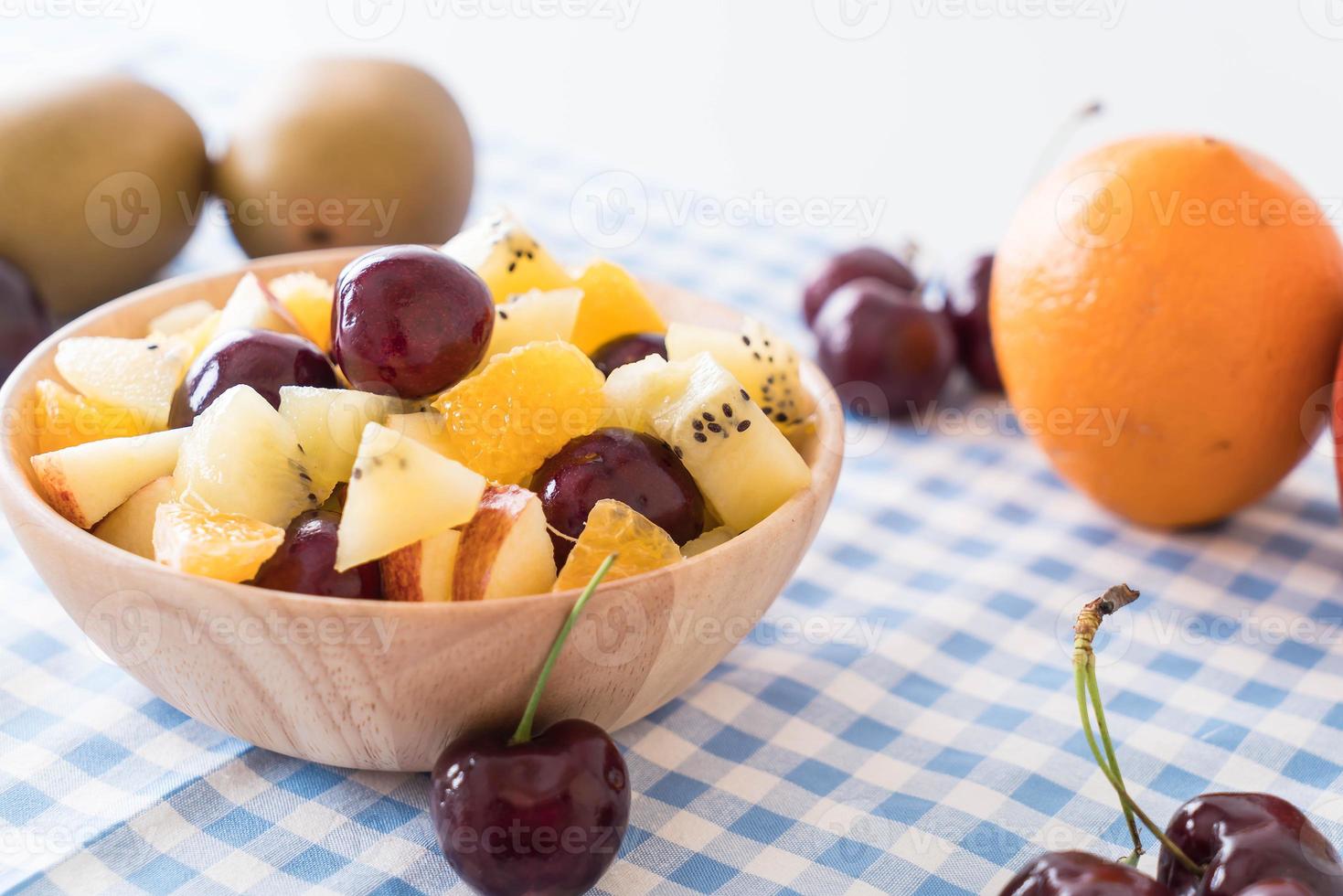 gemengd gesneden fruit in houten kom foto