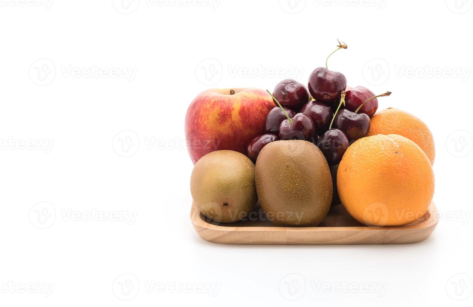 gemengd fruit in houten plaat op witte achtergrond foto