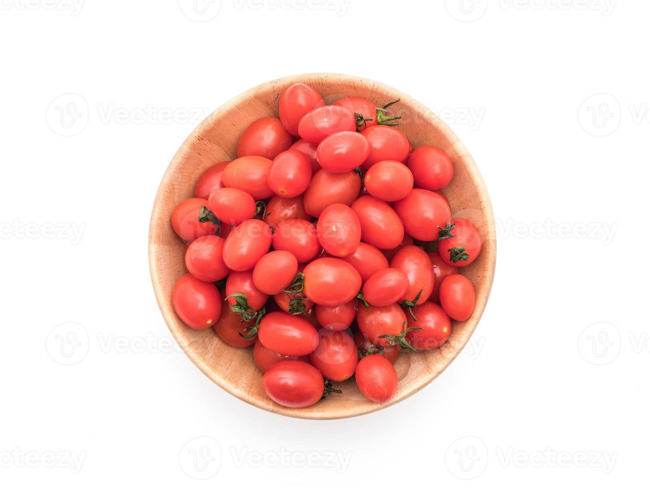 verse tomaten in houten kom op witte achtergrond foto