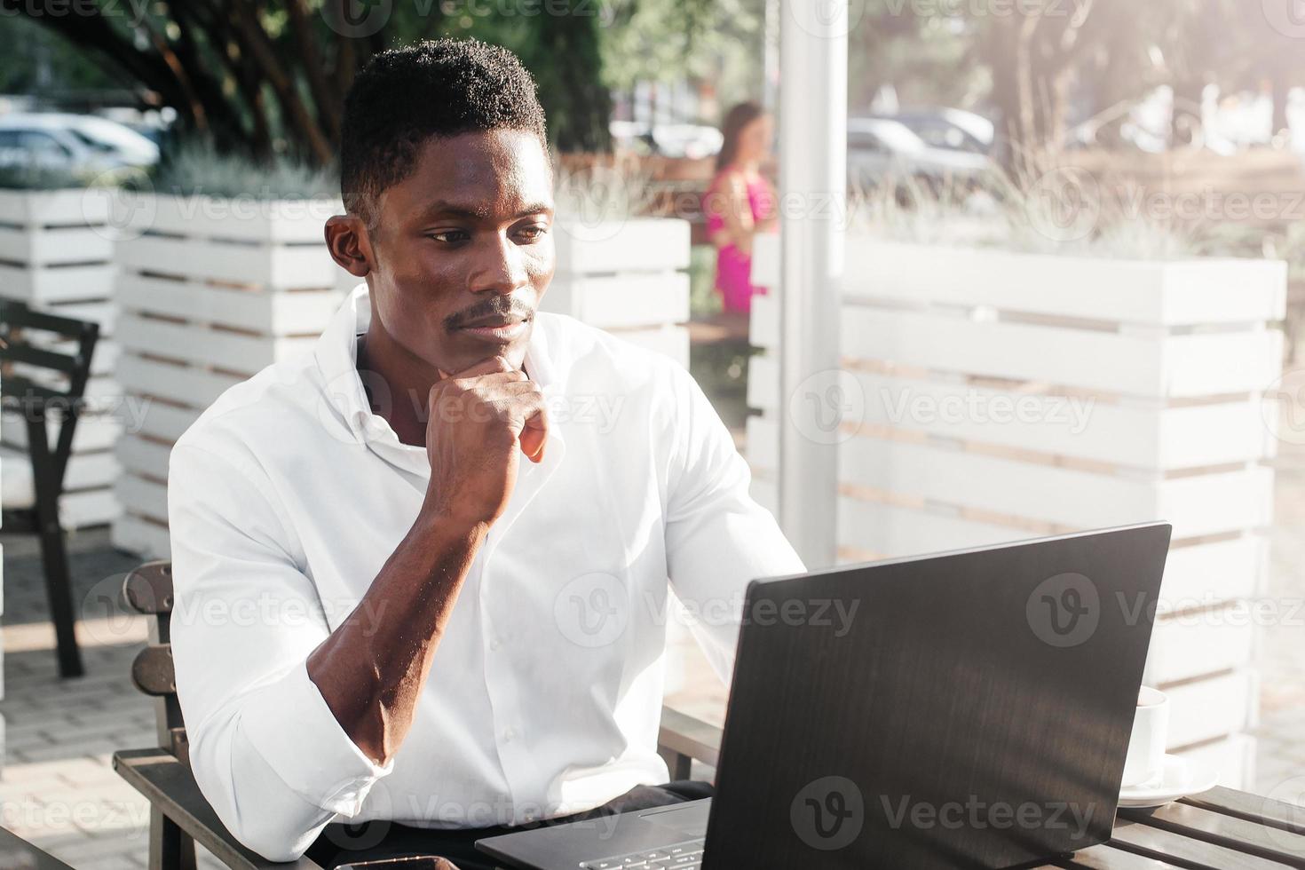 Afro-Amerikaanse zakenman, werkt op een laptop in een café, freelancer foto