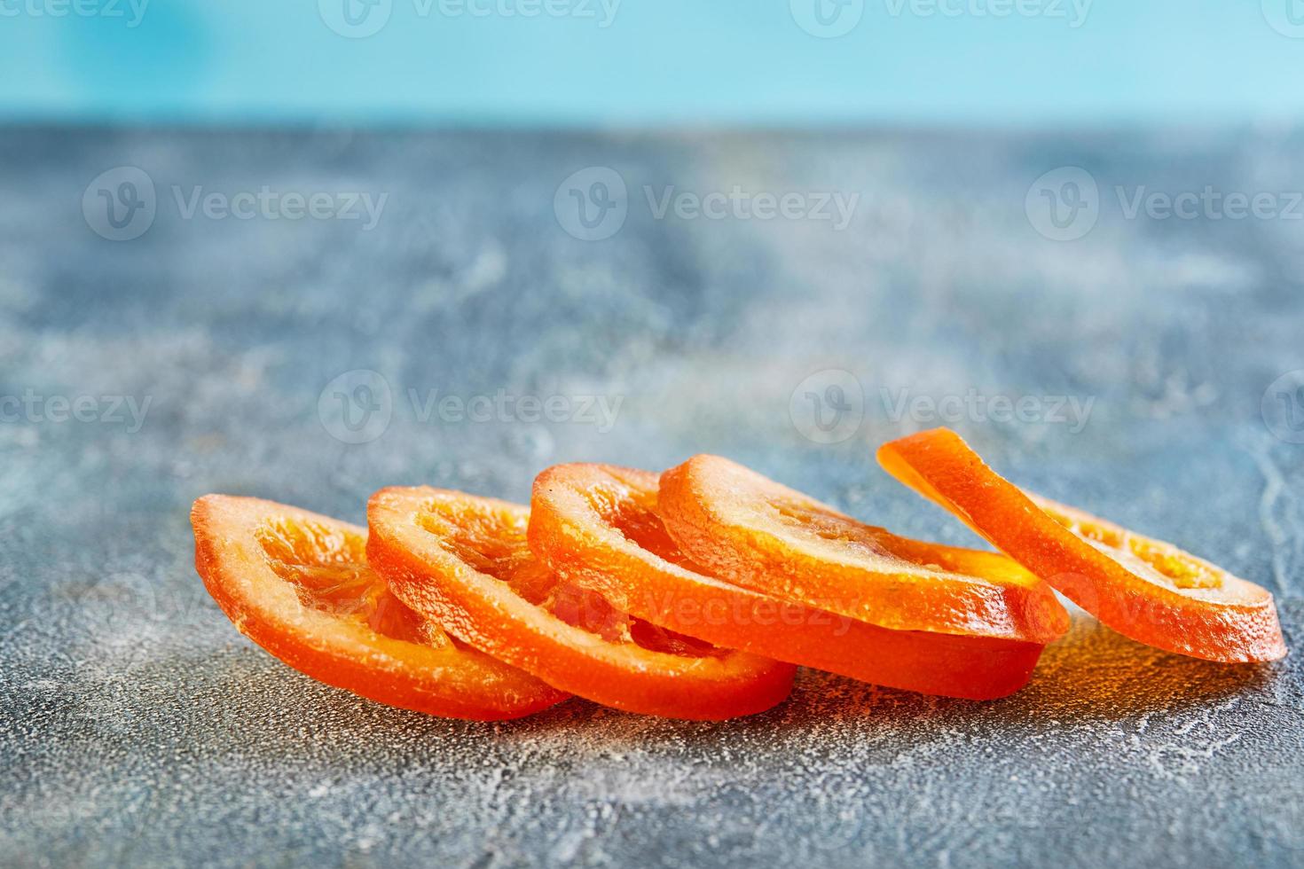 schijfjes gedroogde sinaasappels of mandarijnen op een blauwe achtergrond foto