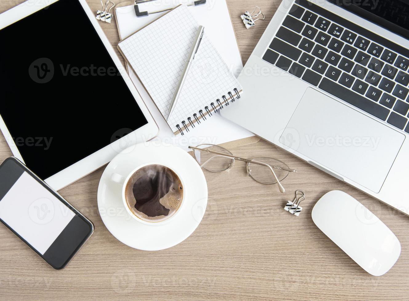 laptop met kantoorbenodigdheden en koffie op tafel. foto