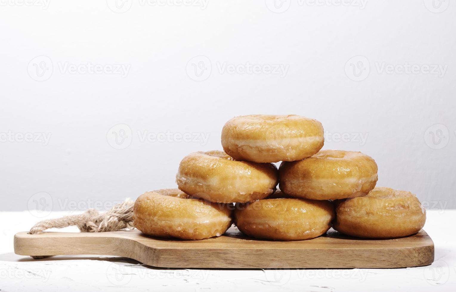 veel donut op een houten bord op witte achtergrond foto