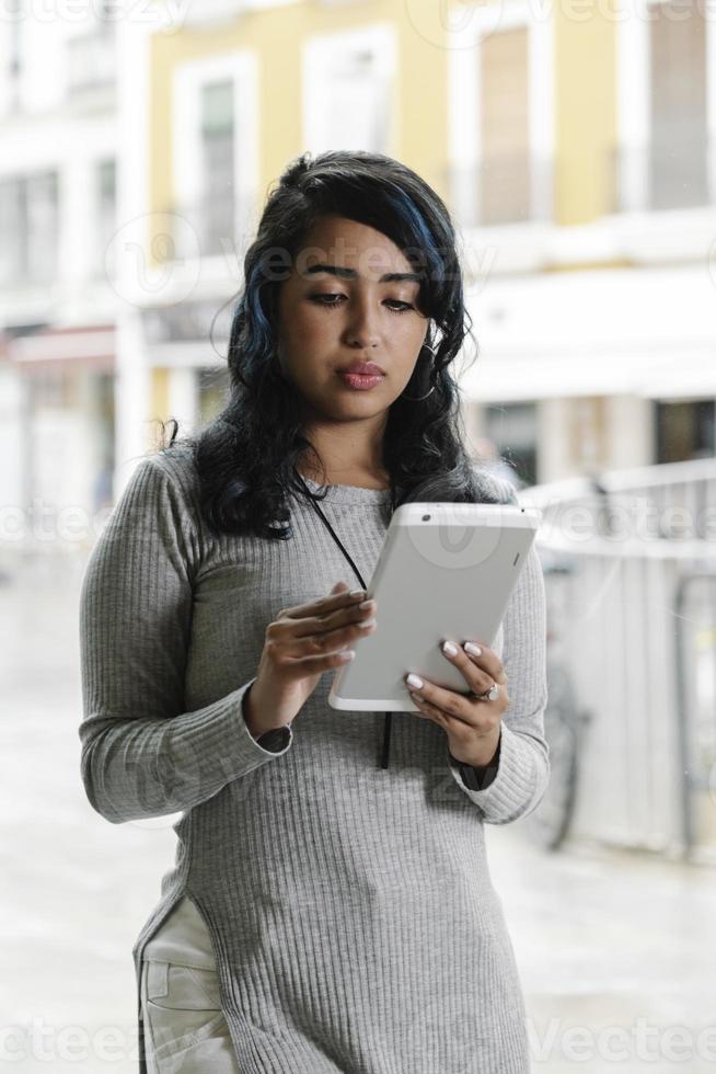 Spaanse vrouw die met een tablet werkt foto