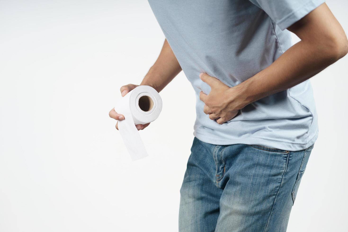 man met zijn maag en papieren zakdoekje die lijden aan diarree. foto