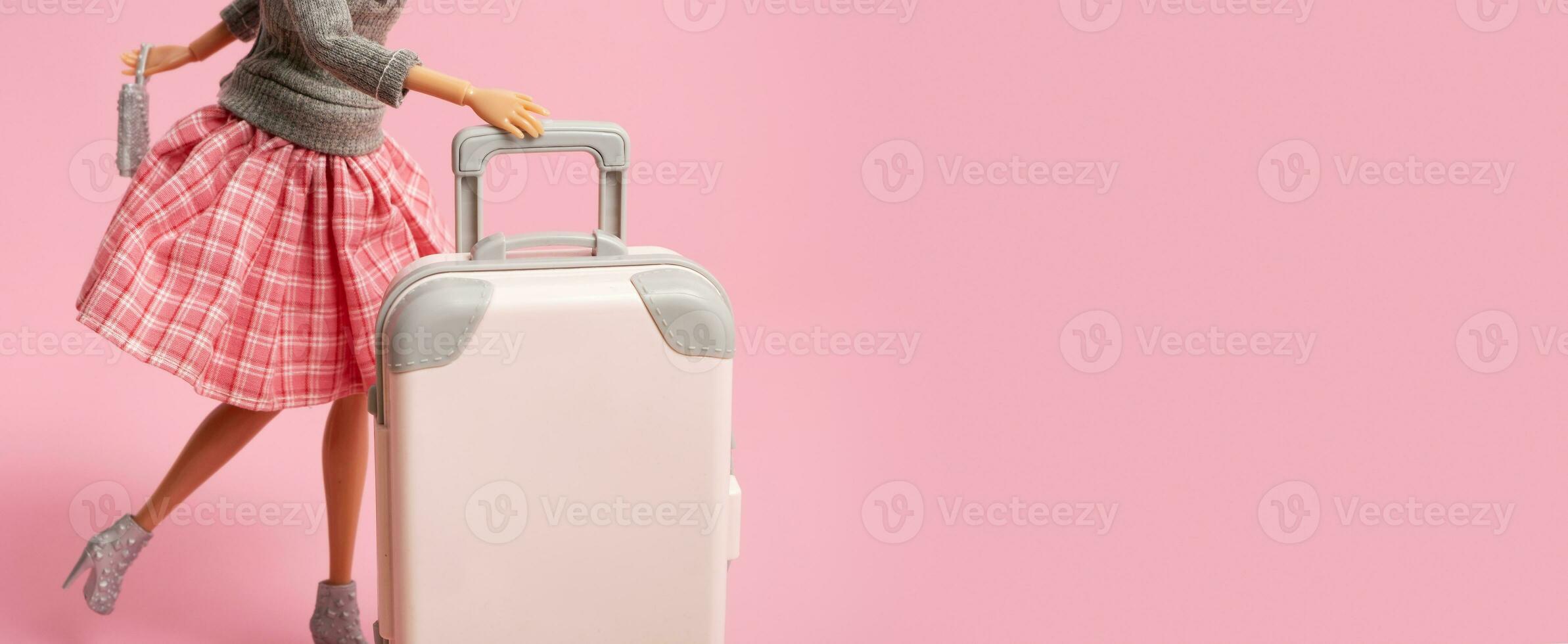 de pop draagt een koffer Aan wielen. reis, vakantie creatief minimalistisch concept. banier met kopiëren ruimte. foto