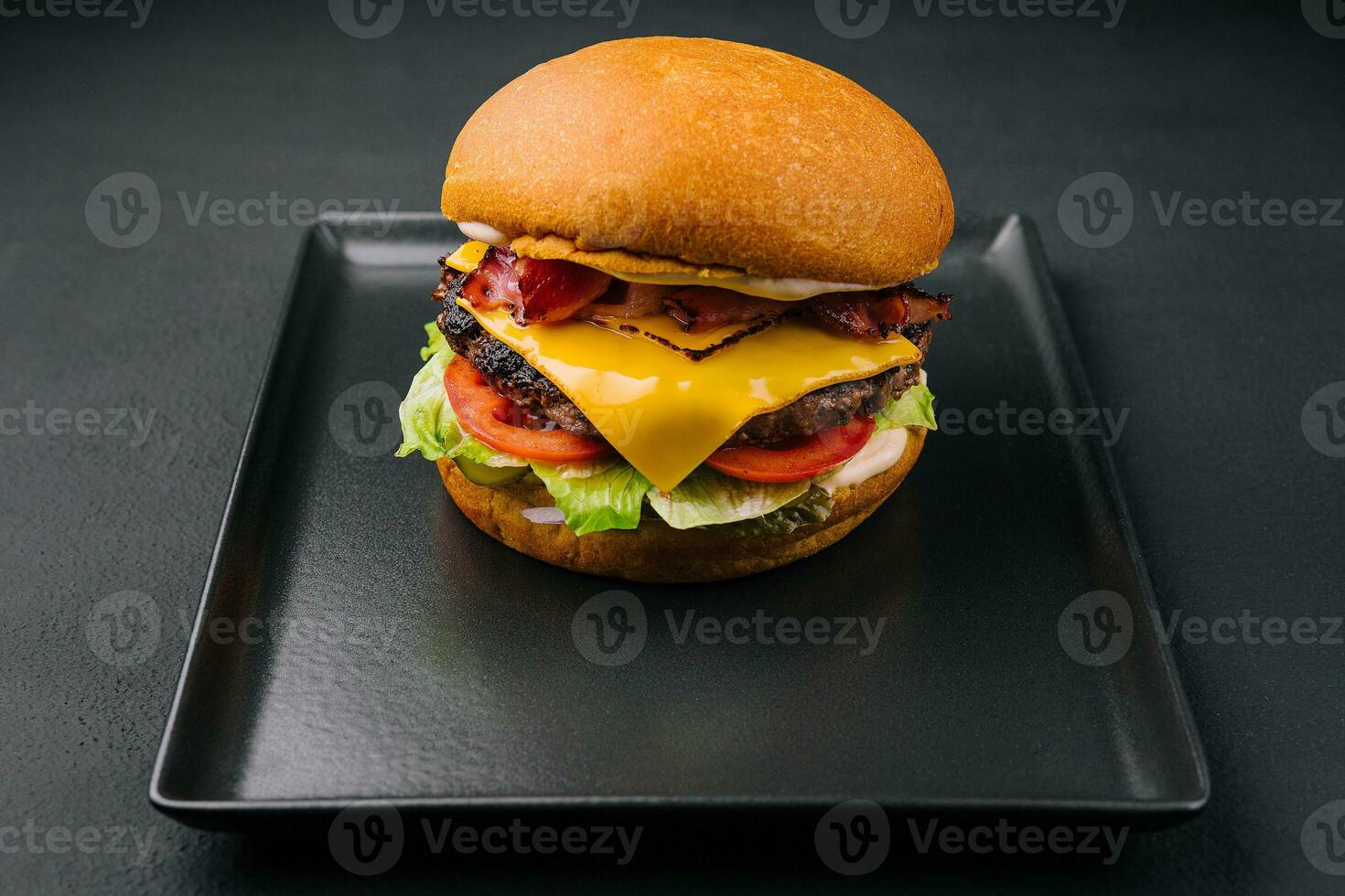 spek hamburger met rundvlees pasteitje Aan zwart dienblad foto