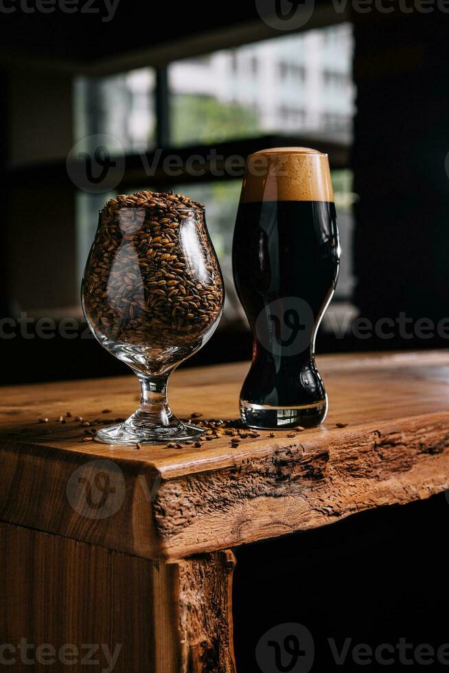 smakelijk donker bier en glas van tarwe Aan houten foto