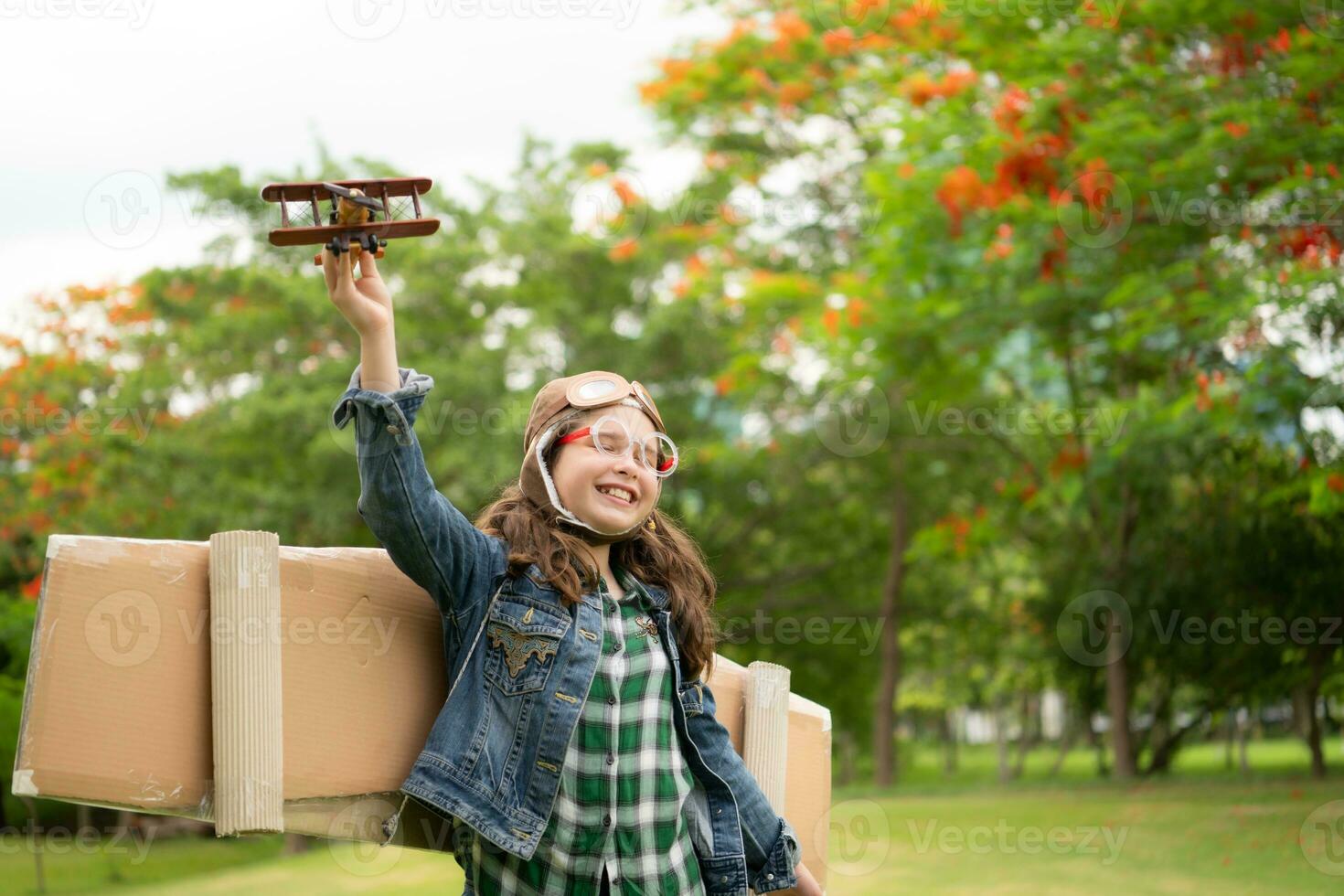 een weinig meisje Aan vakantie Bij de park met een piloot kleding en vliegend apparatuur. rennen in de omgeving van en hebben pret met haar dromen. foto