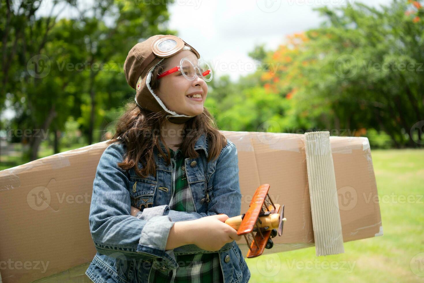 een weinig meisje Aan vakantie Bij de park met een piloot kleding en vliegend apparatuur. rennen in de omgeving van en hebben pret met haar dromen. foto