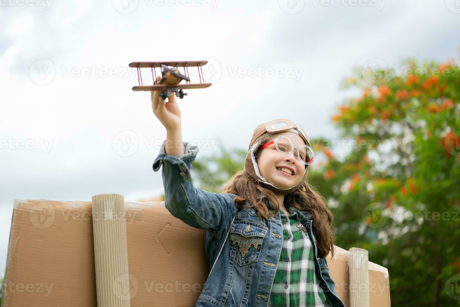 een weinig meisje Aan vakantie Bij de park met een piloot kleding en vliegend apparatuur. rennen in de omgeving van en hebben pret met haar dromen. foto