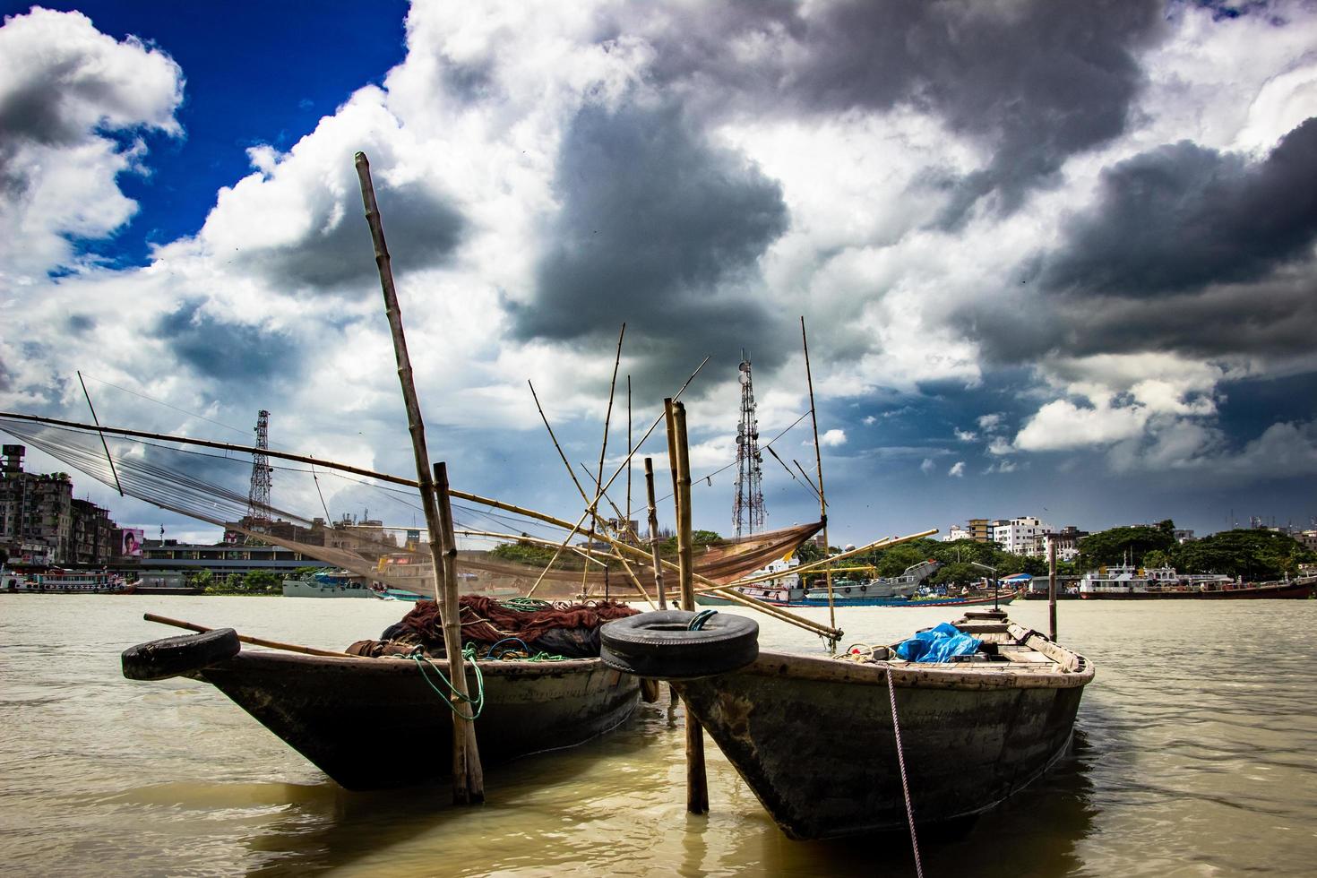 traditionele vissersboot op de rivieroever onder de bewolkte hemel foto