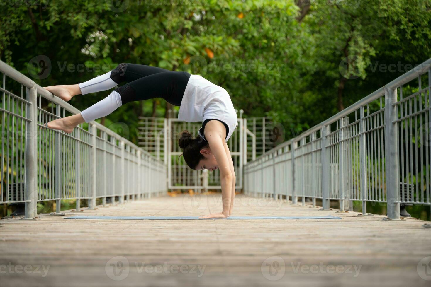 jong vrouw Aan een houten brug in de park met gezond yoga activiteiten foto