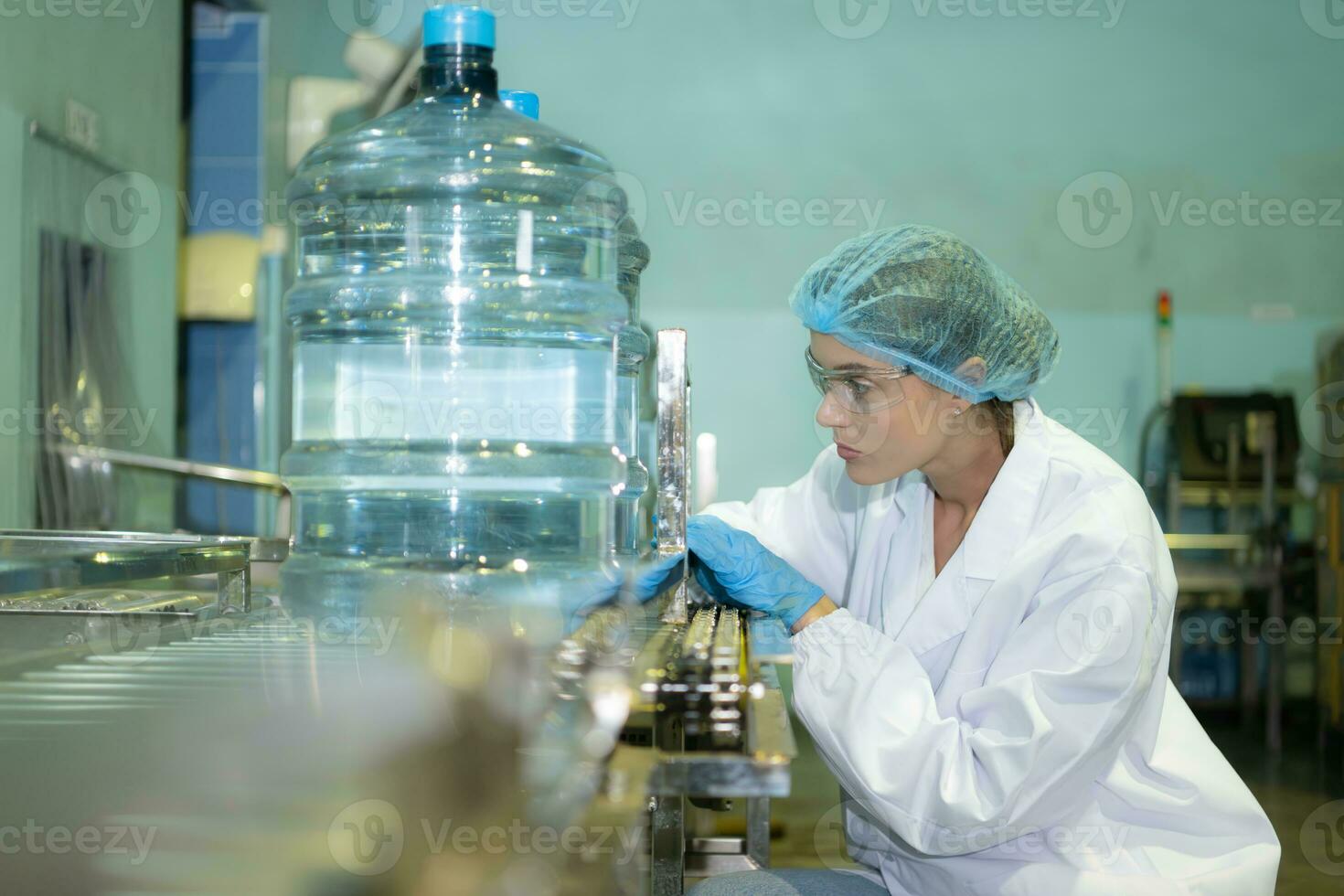 vrouw kwaliteit controle arbeiders in een drinken water fabriek inspecteren de kwaliteit van water tanks voordat importeren de drinken water riem in de tank foto