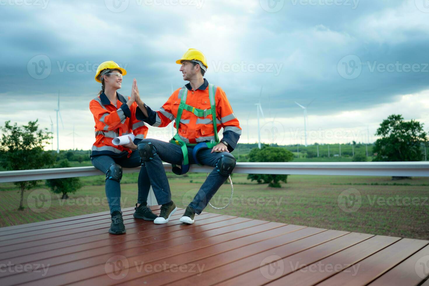 twee ingenieurs bespreken een project van wind turbine, ze zijn zittend Aan een houten platform, de concept van natuurlijk energie van wind. foto