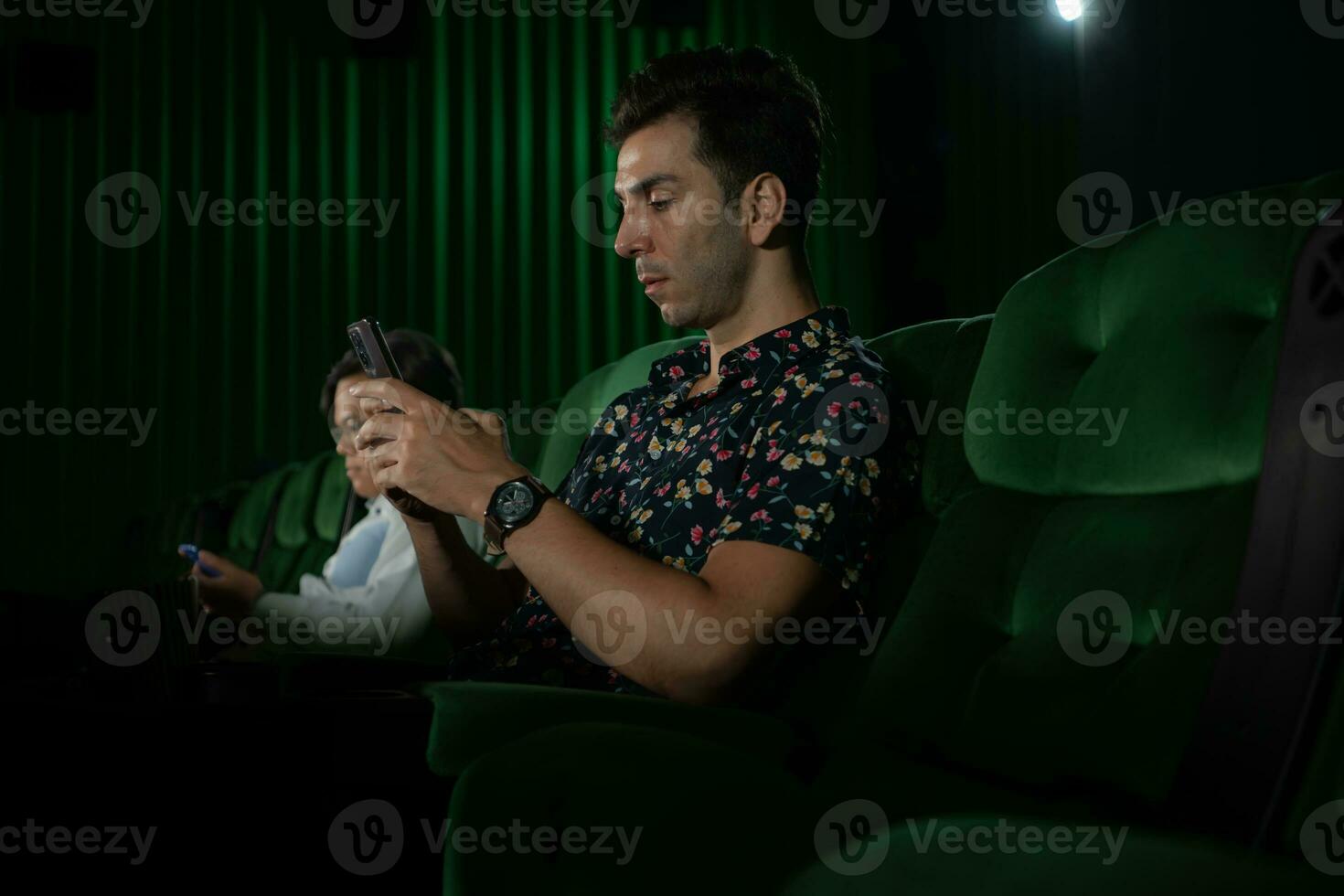 jong paar aan het kijken film in bioscoop, zittend Aan de groen stoelen. foto